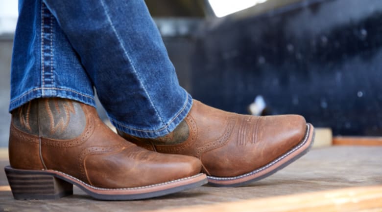 Hand cleaning cowboy boot with water