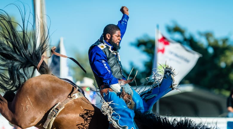 man riding horse at rodeo