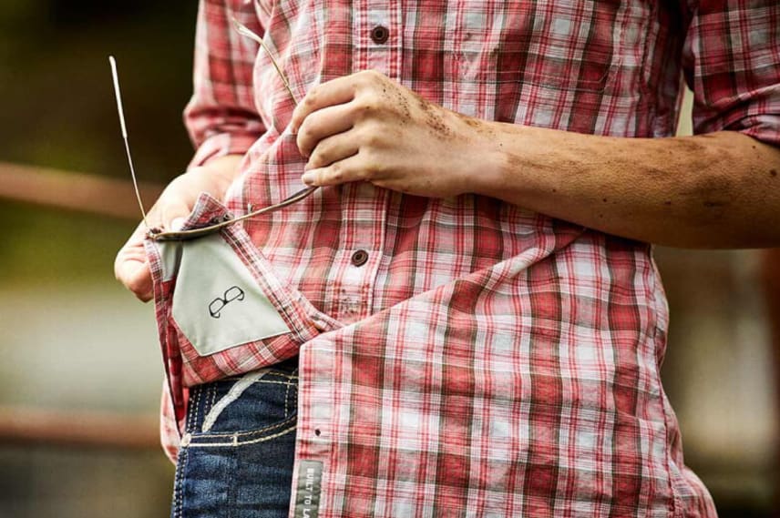 woman cleaning glasses on shirt