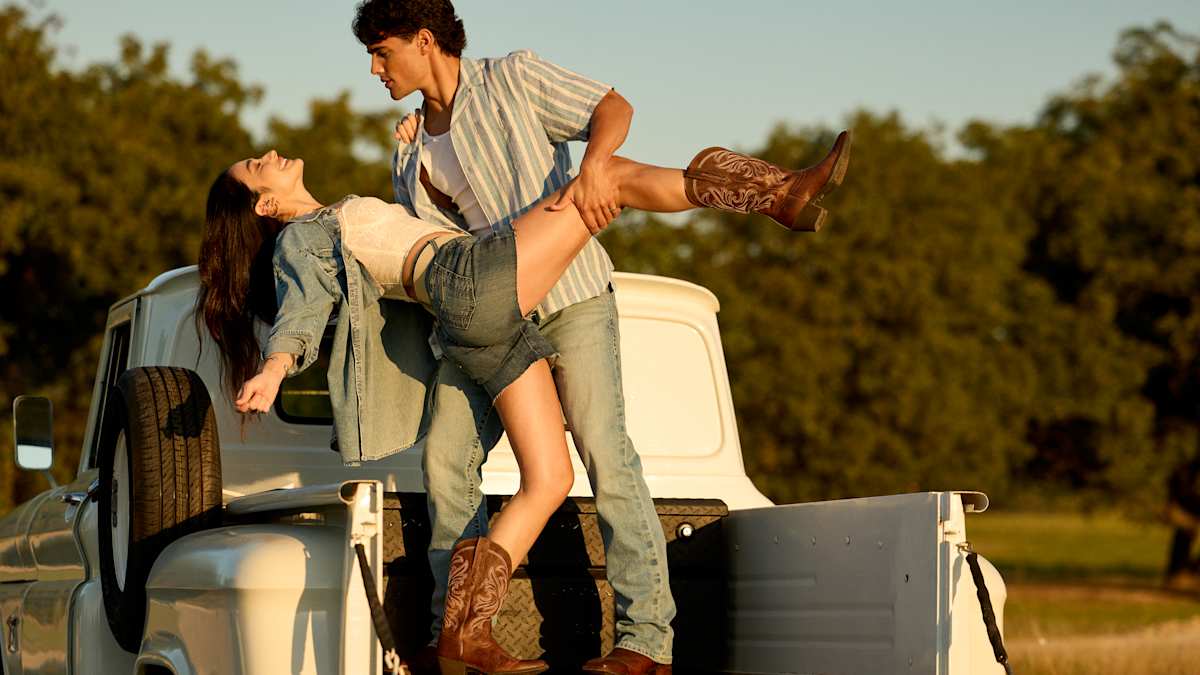 Couple dancing in the back of a truck, wearing Ariat Western boots