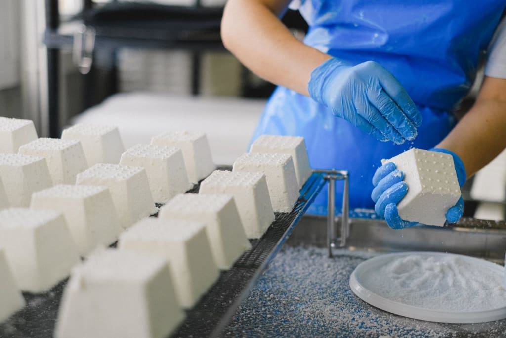 man making ricotta cheese in a dairy factory