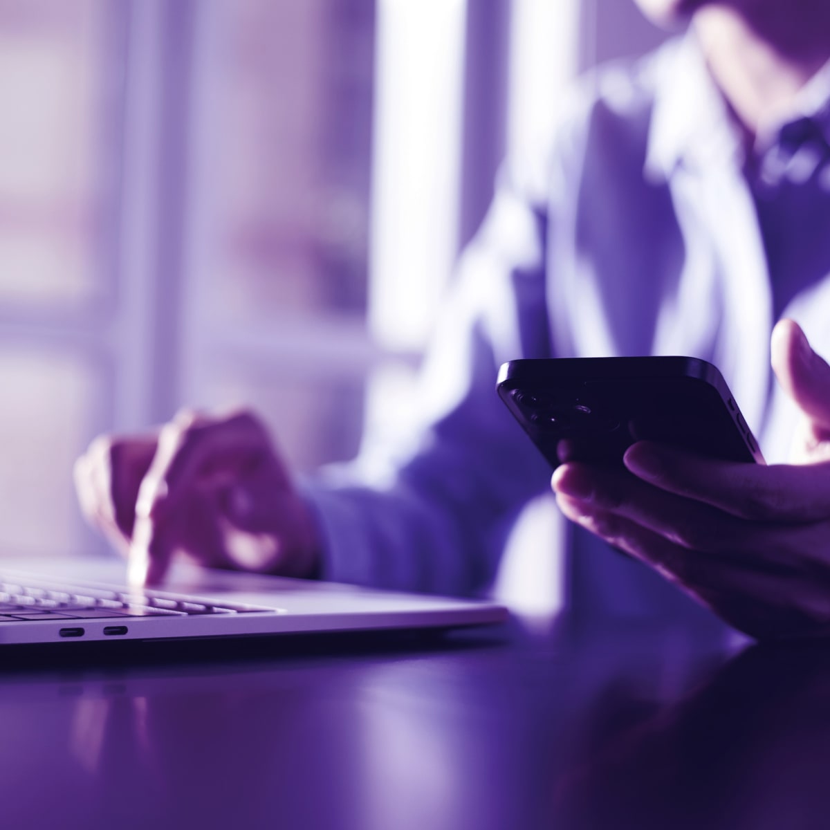 Business woman using mobile phone and working on laptop