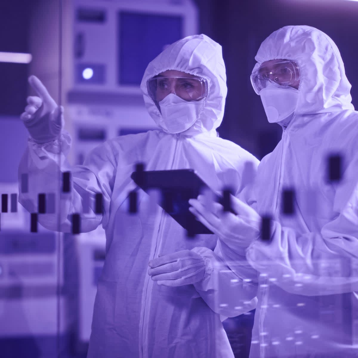 scientist wearing coveralls standing in factory cleanroom