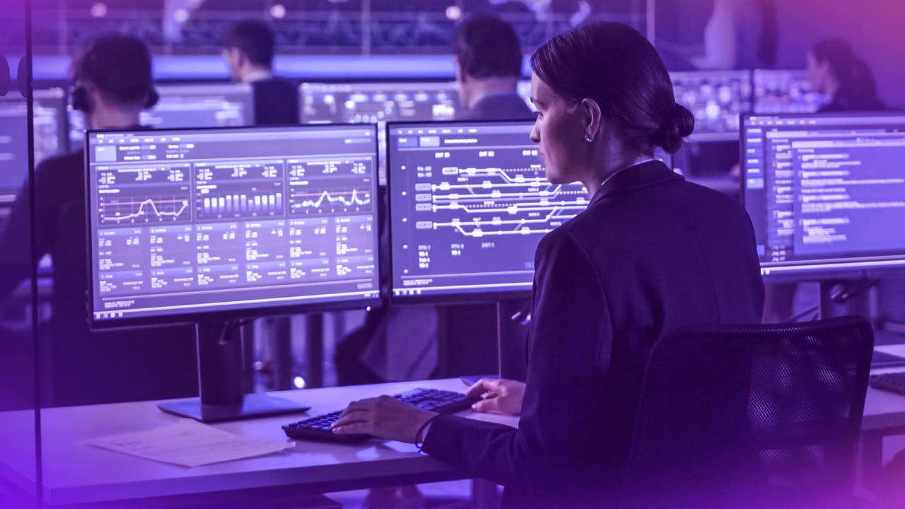 people working on computers in a control room