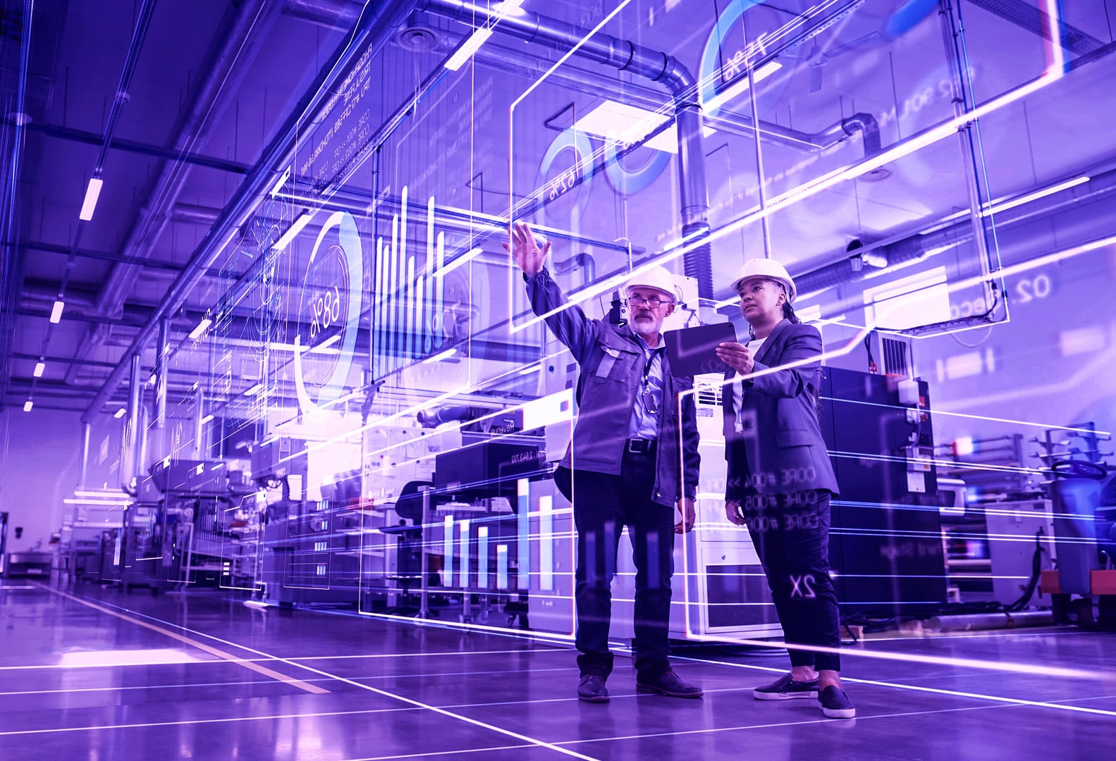 Two engineers looking at virtual data in a factory