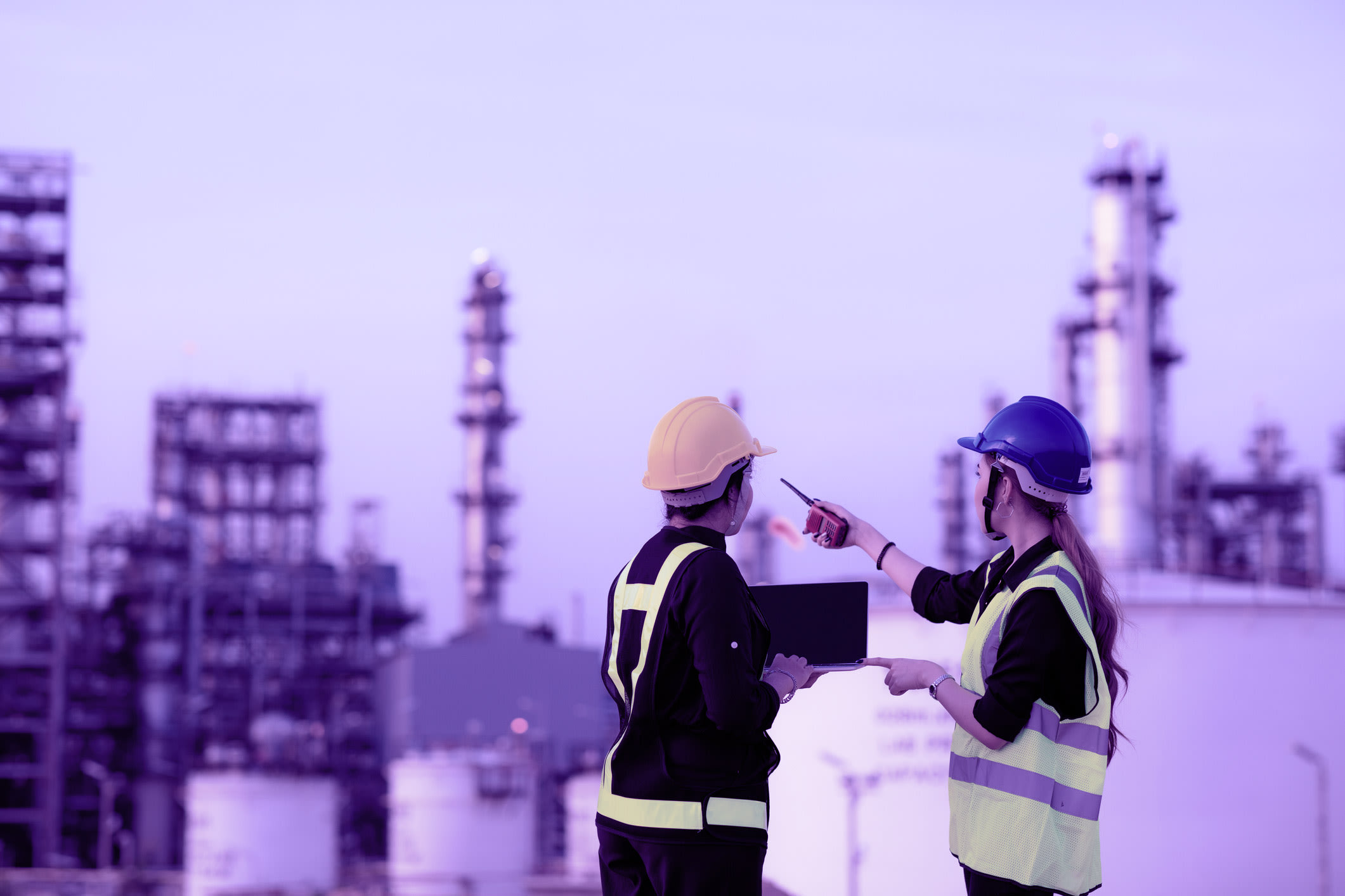two female engineers collaborate at oil refinery