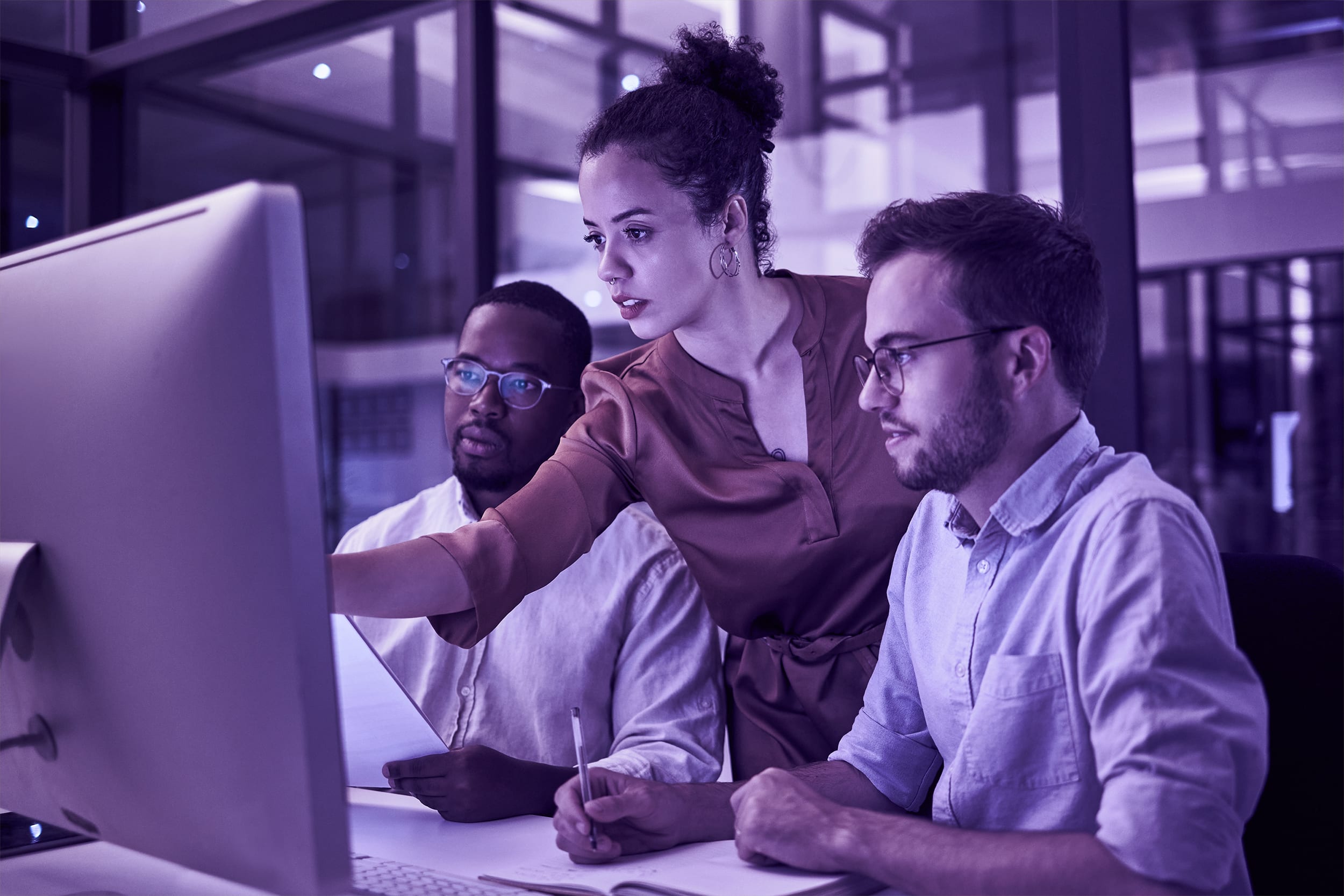 three coworkers collaborate at a computer