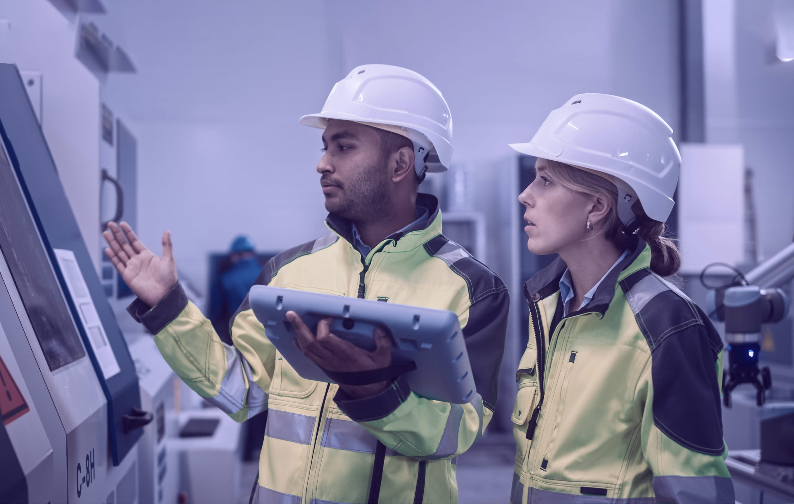 engineers wearing safety vests and hard hats in a factory