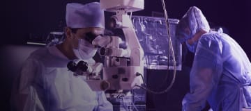 surgeon looks through a microscope in the operating room