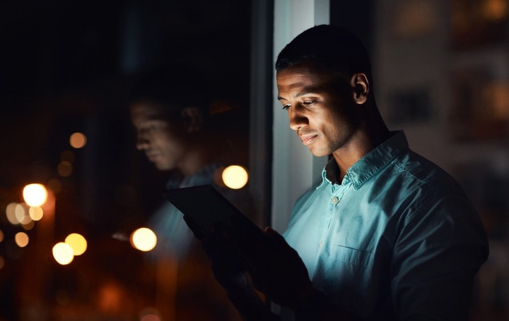 Man viewing tablet at night