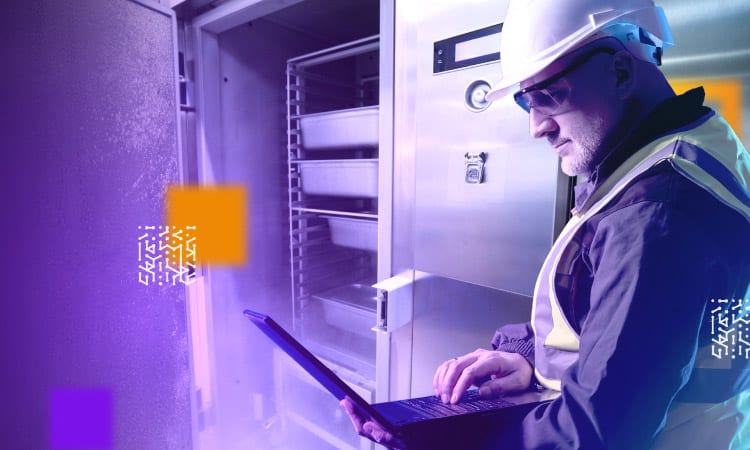 technician with laptop near commercial freezer