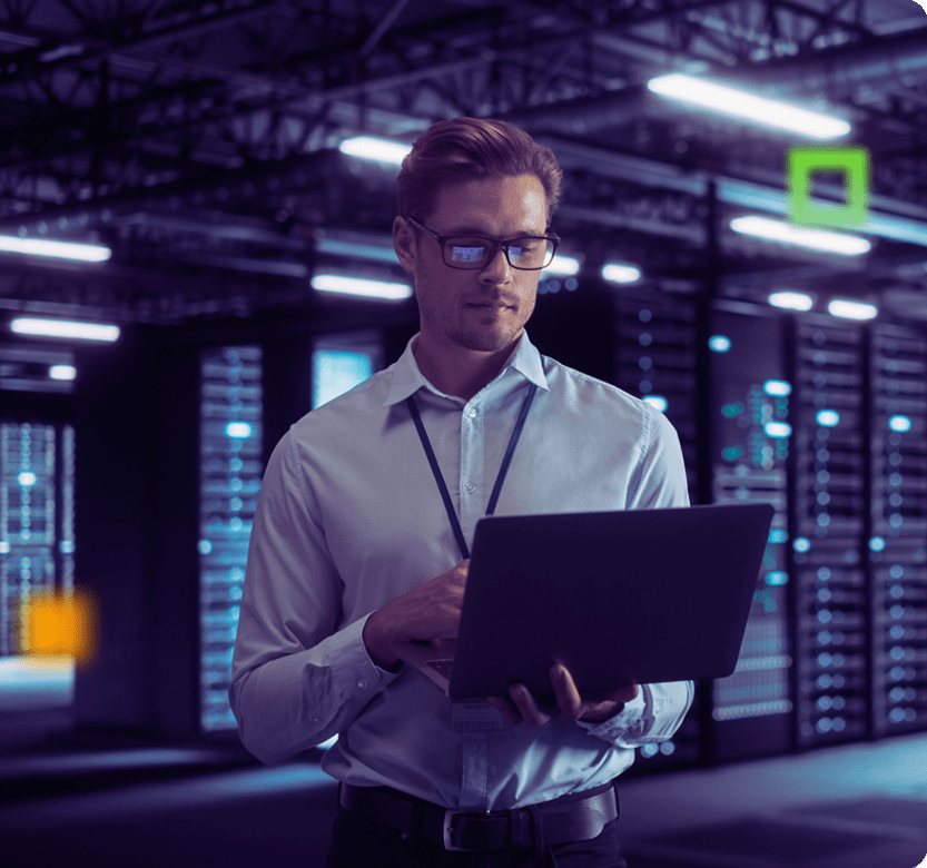 Man holding laptop in a data center