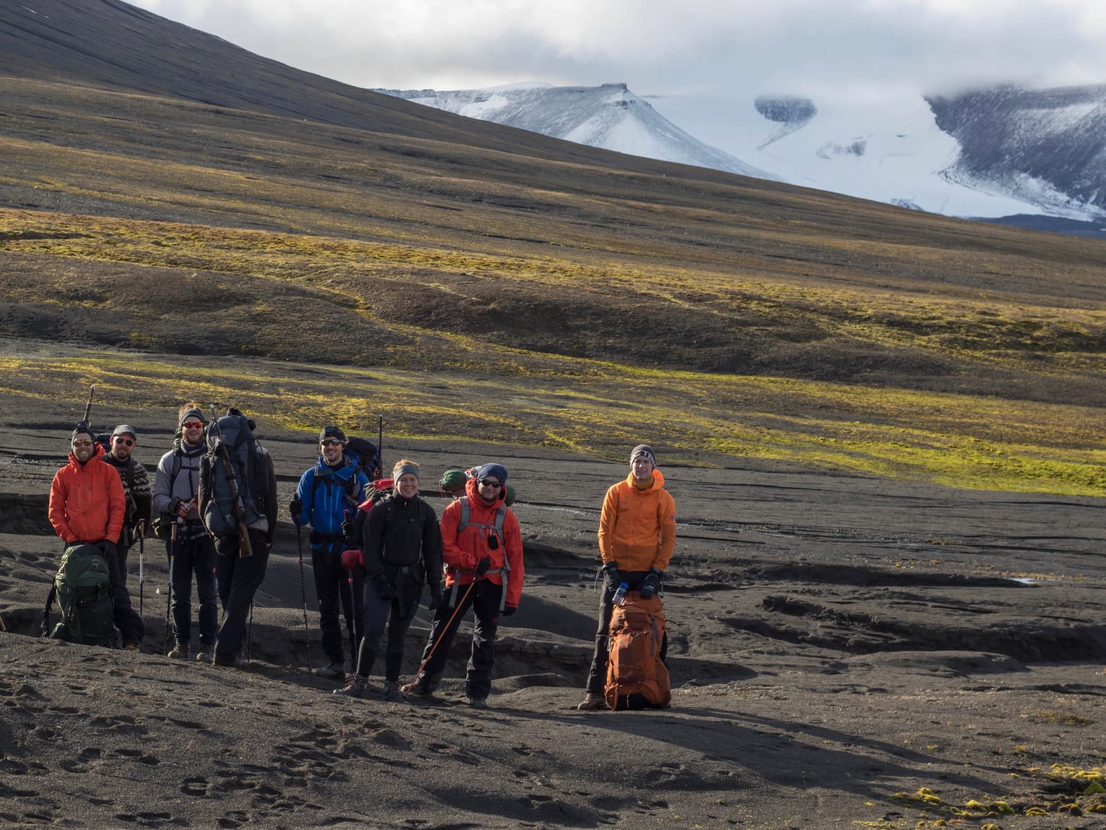 Svalbard route party with packs in open valley terrain