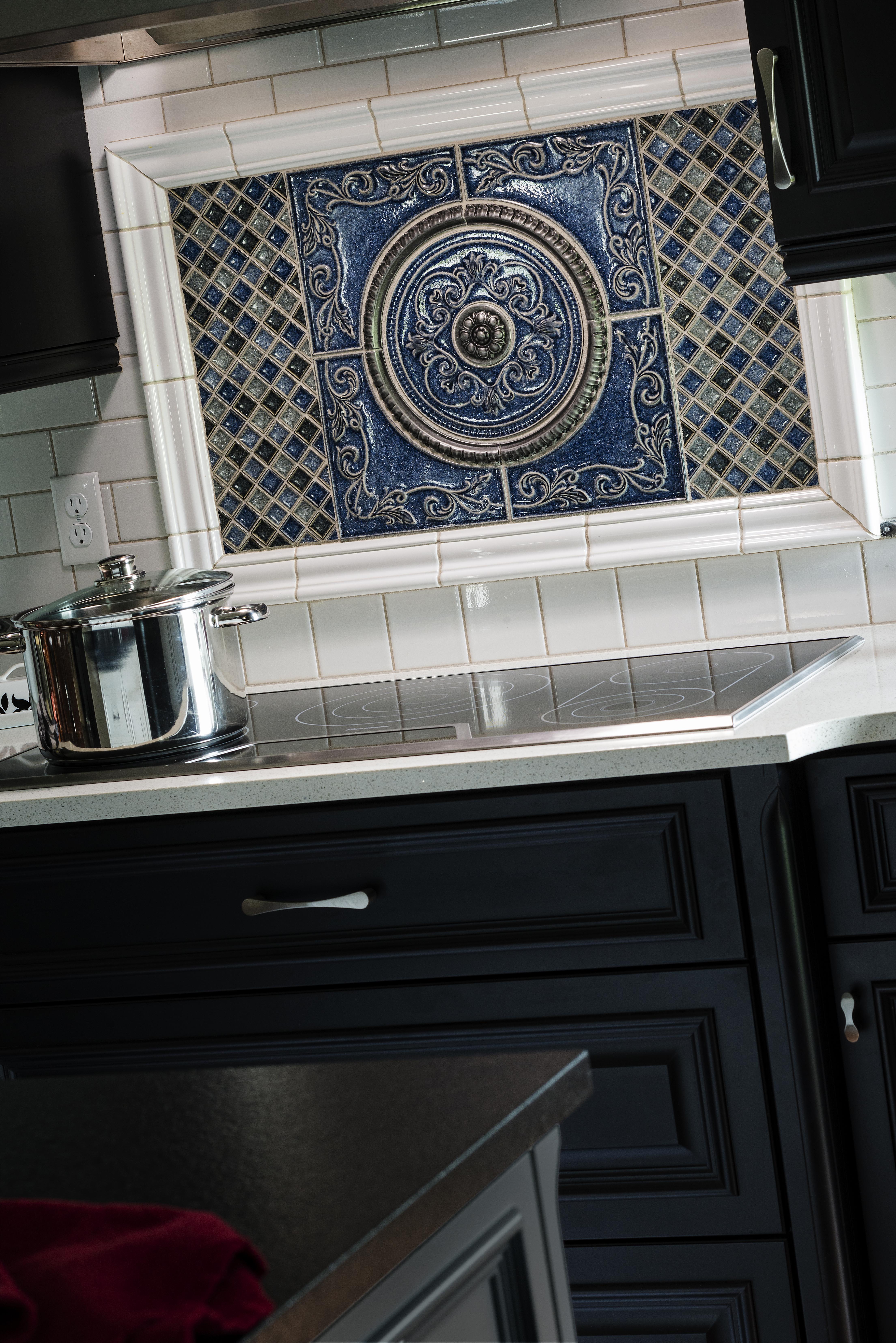 Decorative blue tile backsplash centerpiece above stovetop with ornate patterned design