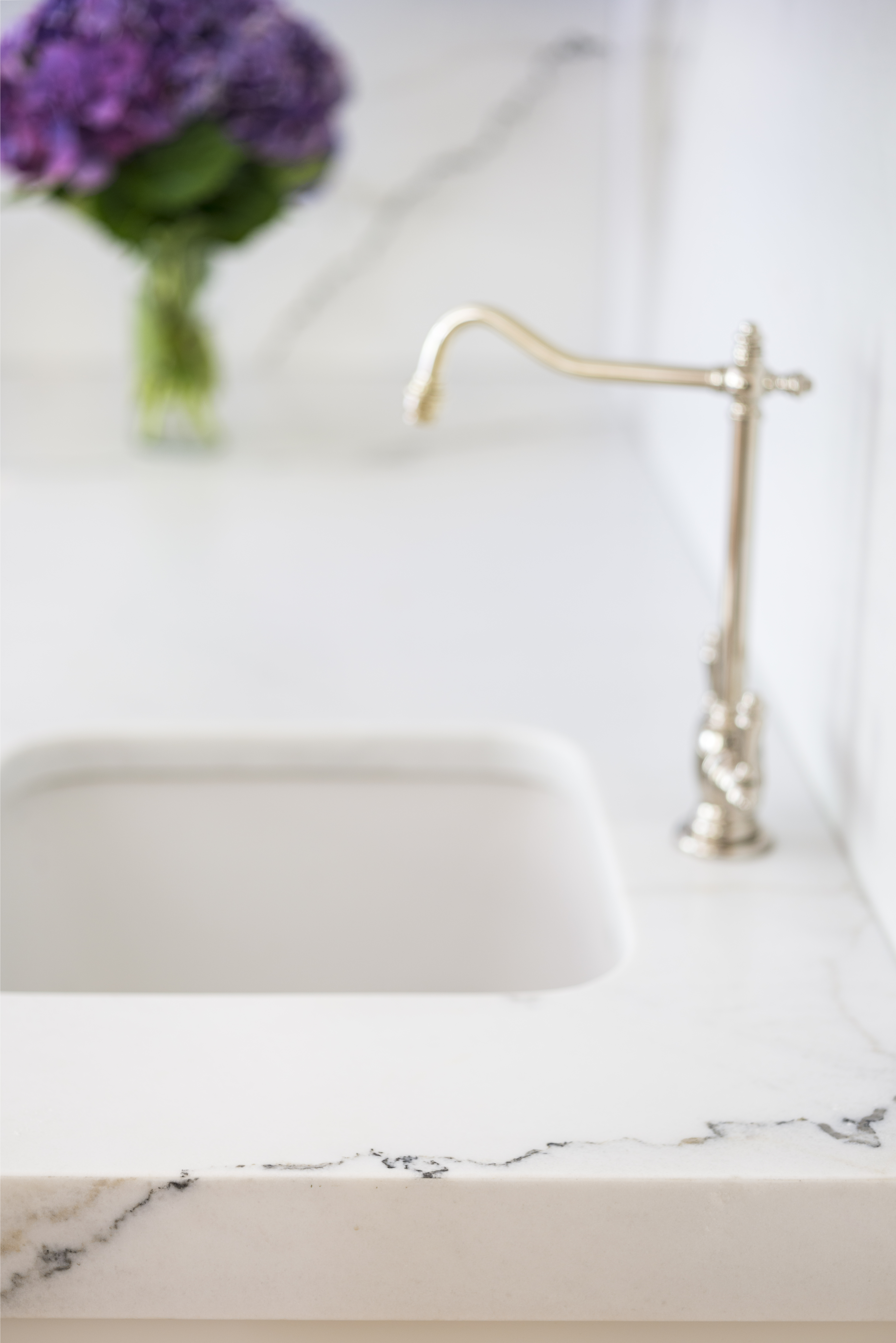 White quartz countertop with undermount sink and brushed brass faucet