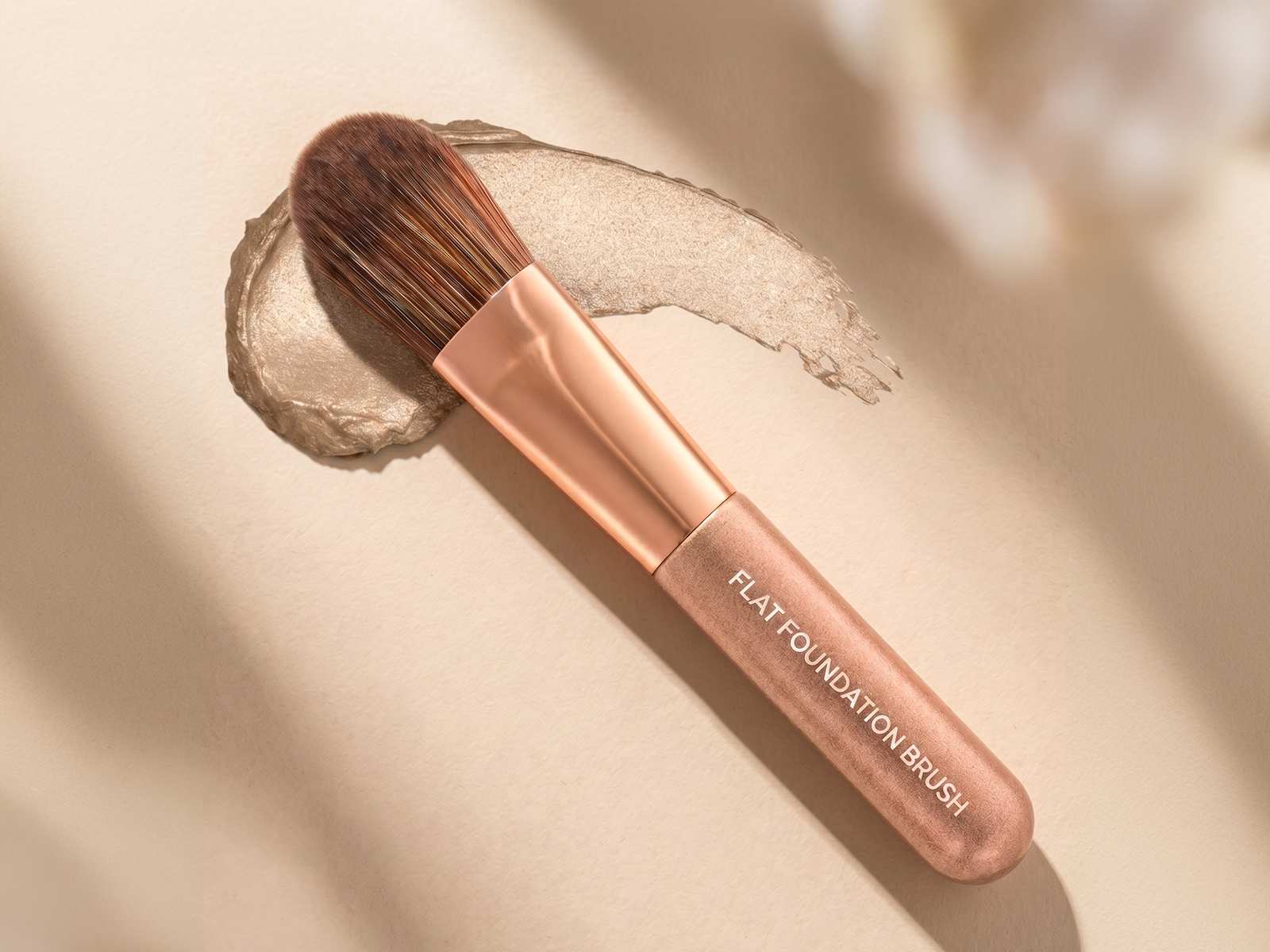 Foundation-Pinsel als Produktbild mit Creme-Textur auf beigem Hintergrund