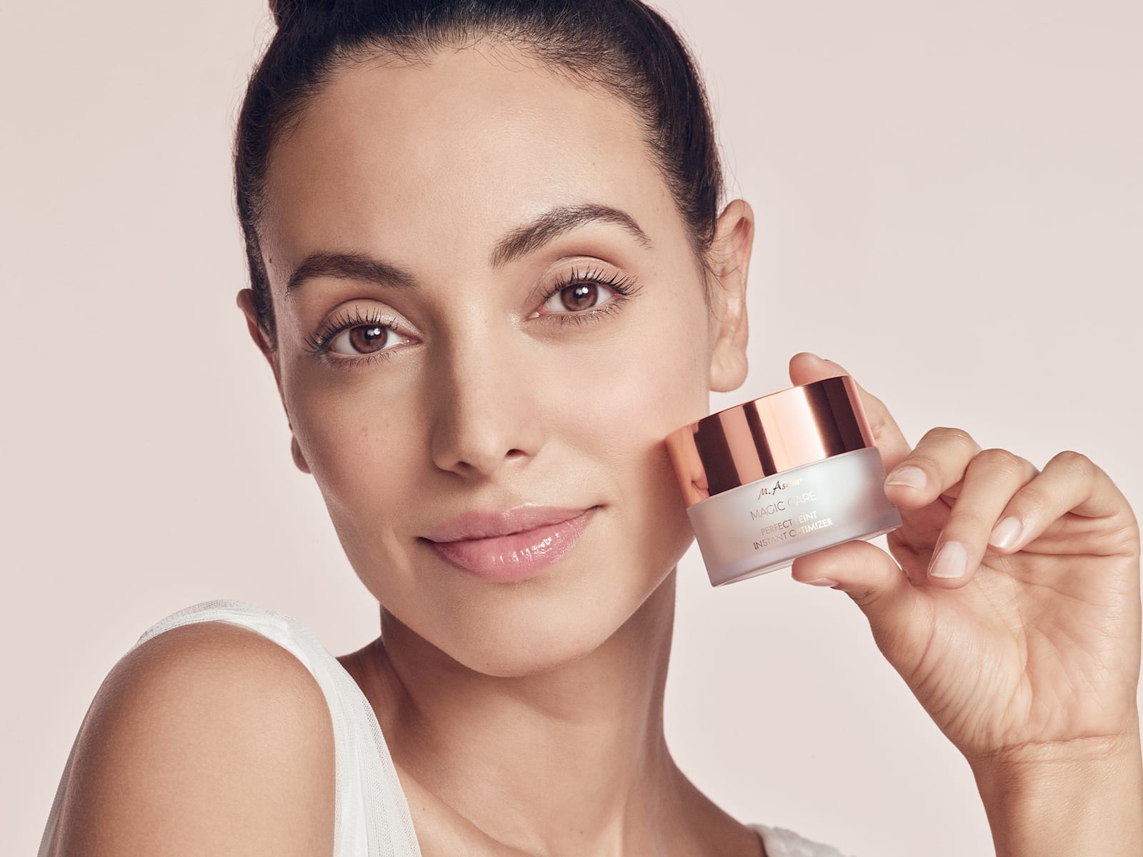 Beauty-Porträt mit Frau, die einen Cremetiegel neben ihr Gesicht hält