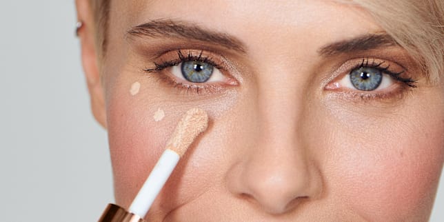Frau trägt den Magic Finish Highclass Liquid Concealer von M.Asam auf ihre Augenringe uaf