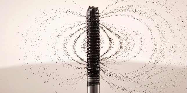 Detailaufnahme einer schwarzen Mascara-Bürste mit feinen Produktpartikeln