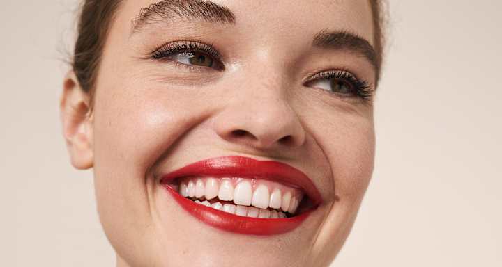 Beauty-Porträt mit rotem Lippenstift und lächelndem Gesicht