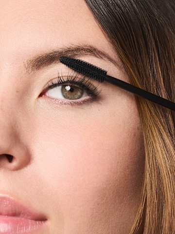 Model trägt Mascara auf