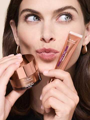 Femme avec des produits de maquillage à la main