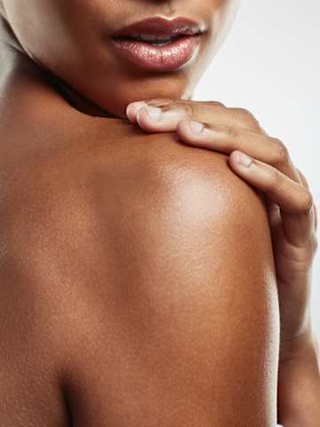 Application de crème sur l’épaule, gros plan beauté peau lumineuse