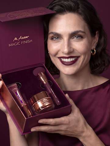 Beauty-Porträt einer Frau mit dunklem Lippenstift und geöffnetem M. Asam MAGIC FINISH Geschenkset