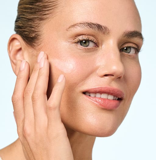 Beauty-Porträt Frau trägt M. Asam AQUA INTENSE Creme auf Wange auf, glowy Teint