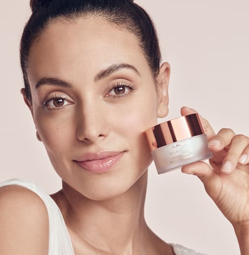Beauty-Porträt mit Frau, die einen Cremetiegel neben ihr Gesicht hält