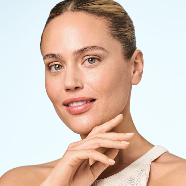 Portrait beauté femme maquillage naturel, main au menton, teint uniforme