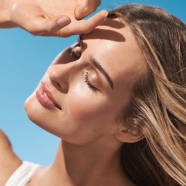 Beauty-Porträt mit geschlossenen Augen, Hand im Gesicht, glowy Haut