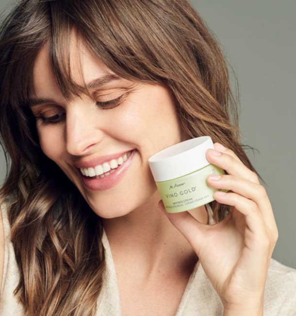 Frau hält Tiegel der Vino Gold 24 Stunden Face Cream von M.Asam in der Hand