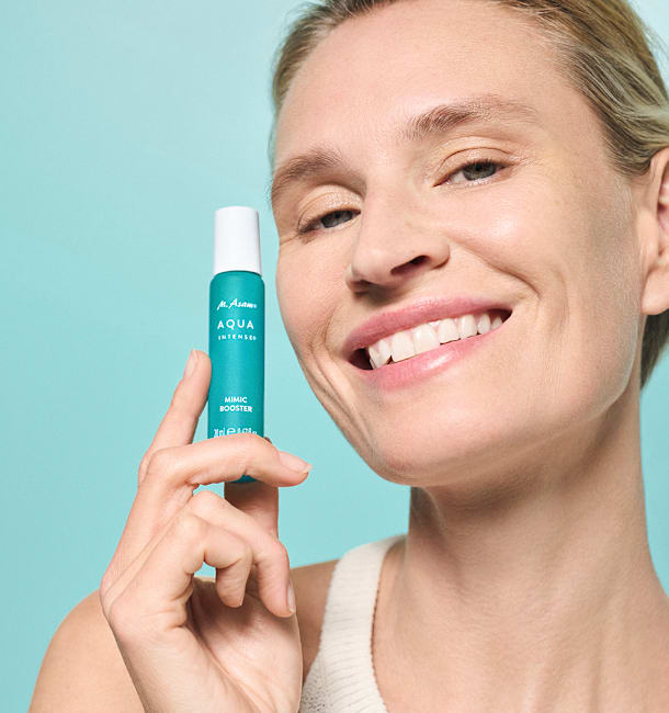 Frau hält das Aqua Intense Mimic Booster Serum von M. Asam in ihrer Hand