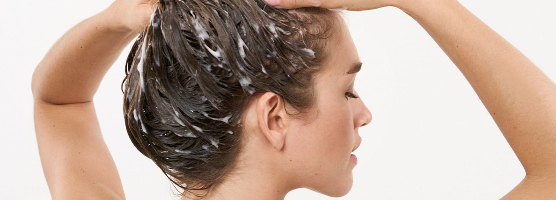 Frau wäscht sich die Haare mit einem panthenolhaltigen Shampoo von M.Asam