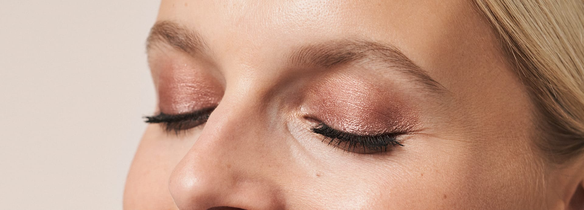 Frau zeigt ihr Augen-Make-up von M.Asam