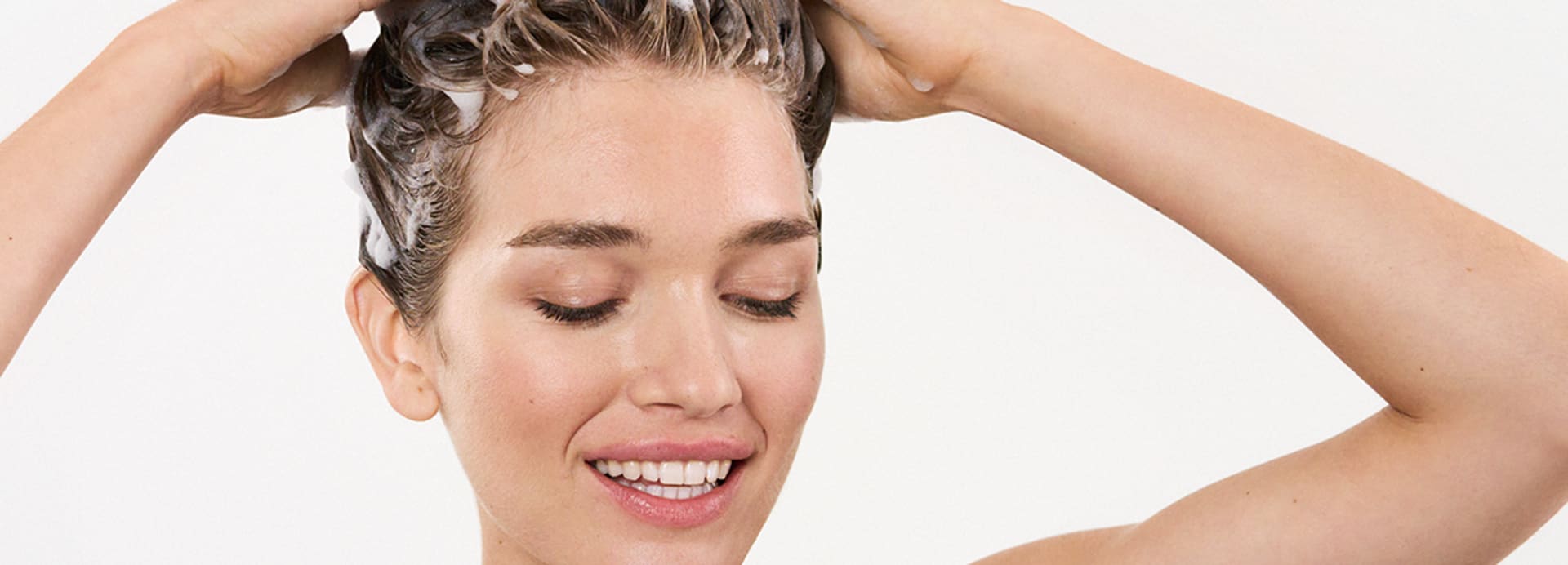Frau wäscht sich die Haare mit einem silikonfreien Shampoo von M.Asam