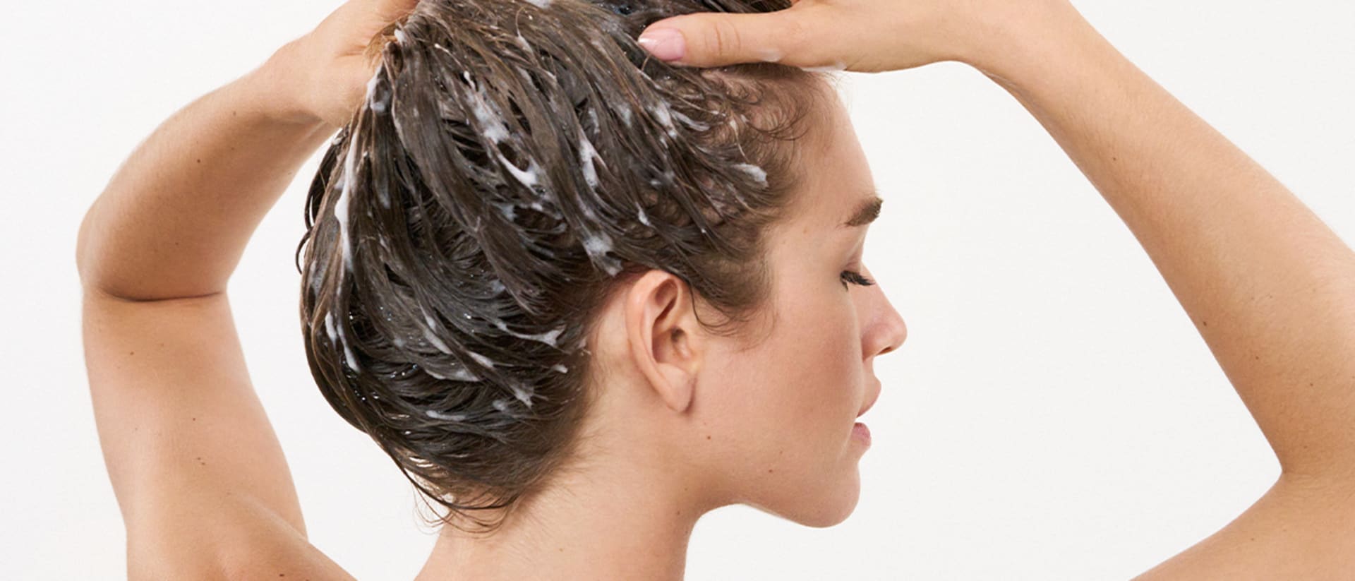 Frau wäscht sich die Haare mit einem panthenolhaltigen Shampoo von M.Asam