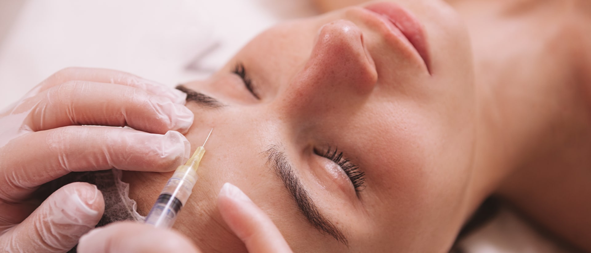 Frau kriegt Botox in die Stirn gespritzt