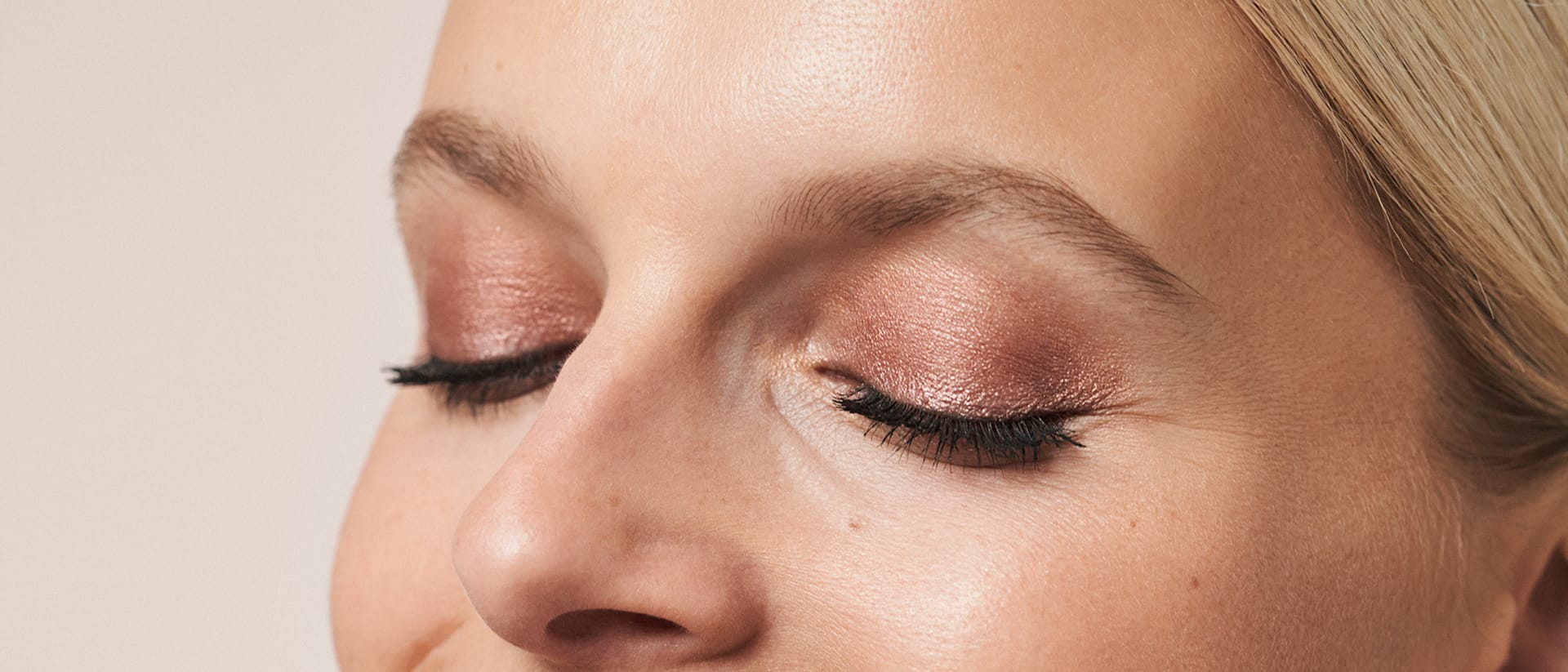 Frau zeigt ihr Augen-Make-up von M.Asam