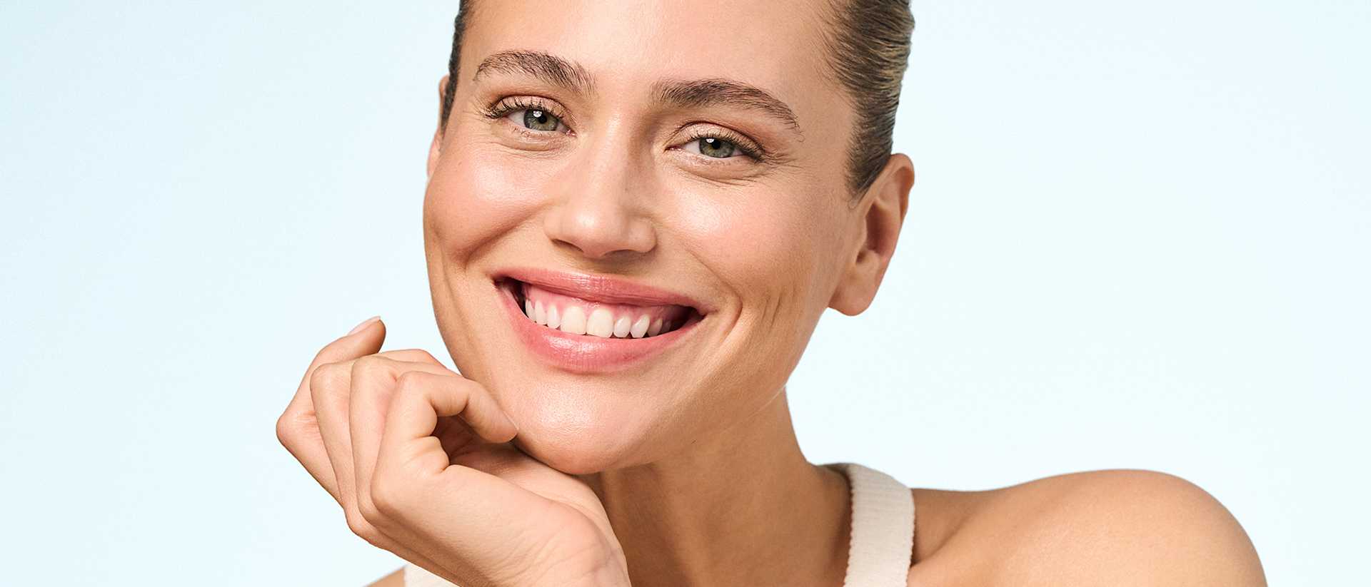 Frau blickt nach Anwendung der AQUA INTENSE Hautpflege zufrieden in die Kamera – Kampagnenmotiv mit Fokus auf strahlender, gepflegter Haut