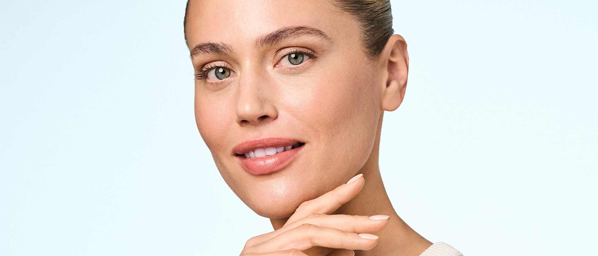 Beauty-Porträt Frau mit natürlichem Make-up, Hand am Kinn, ebenmäßiger Teint