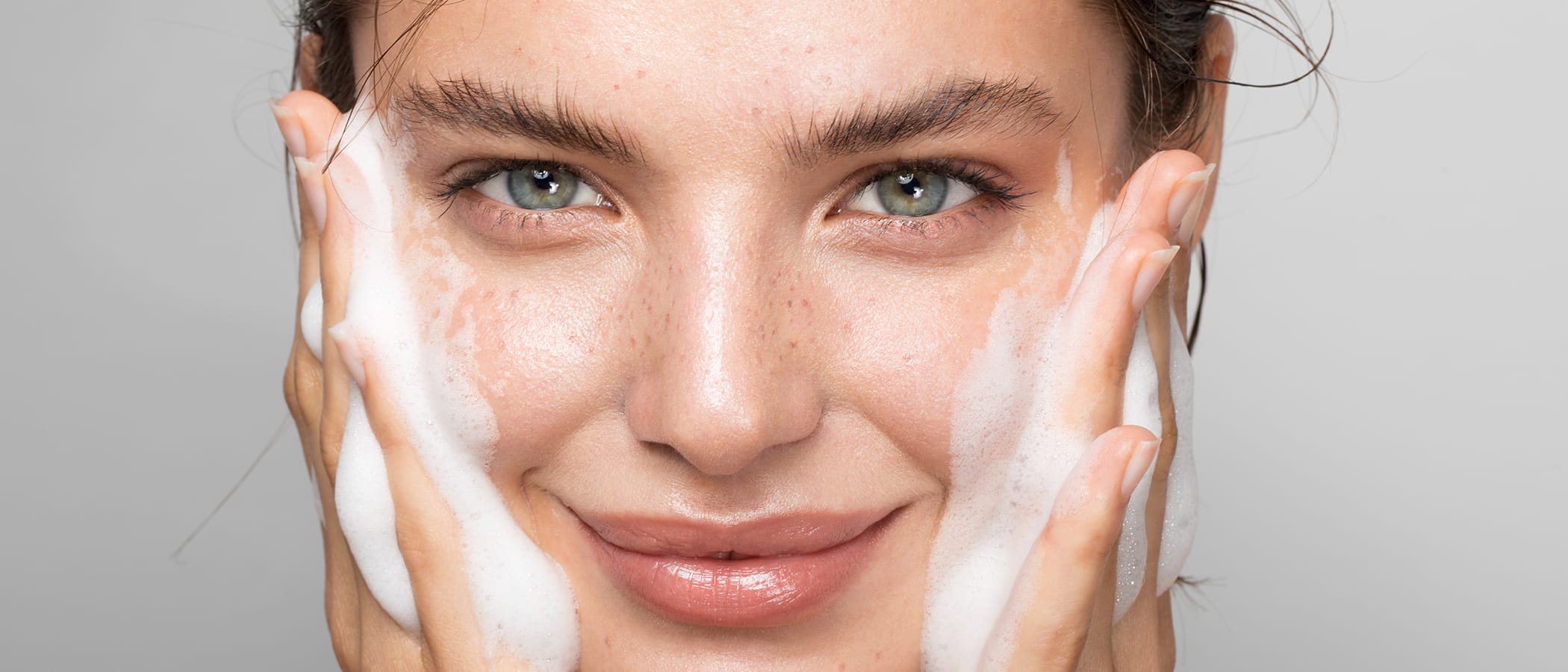 Frau reinigt ihr Gesicht mit dem Magic Care Glow Cleansing Balm von M.Asam