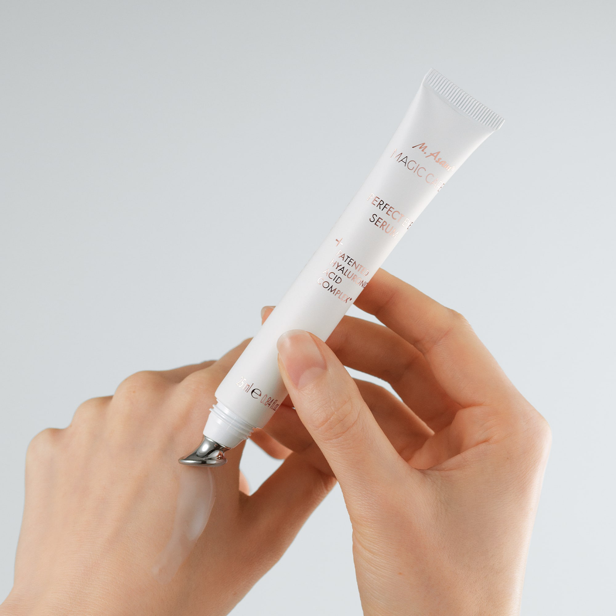 Frau trägt das Magic Care Perfect Eye Serum von M.Asam mit dem integrierten Applikator auf ihren Handrücken auf