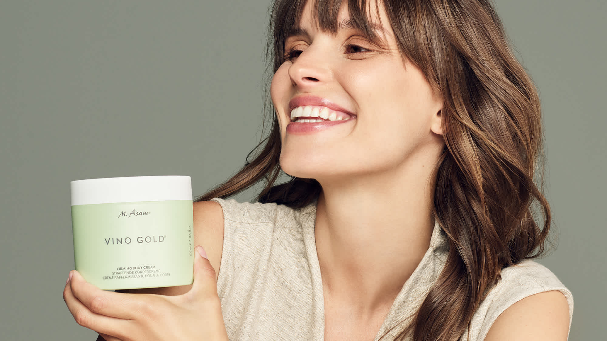 Frau im Beauty-Porträt mit VINO GOLD Cremetiegel von M. Asam in der Hand