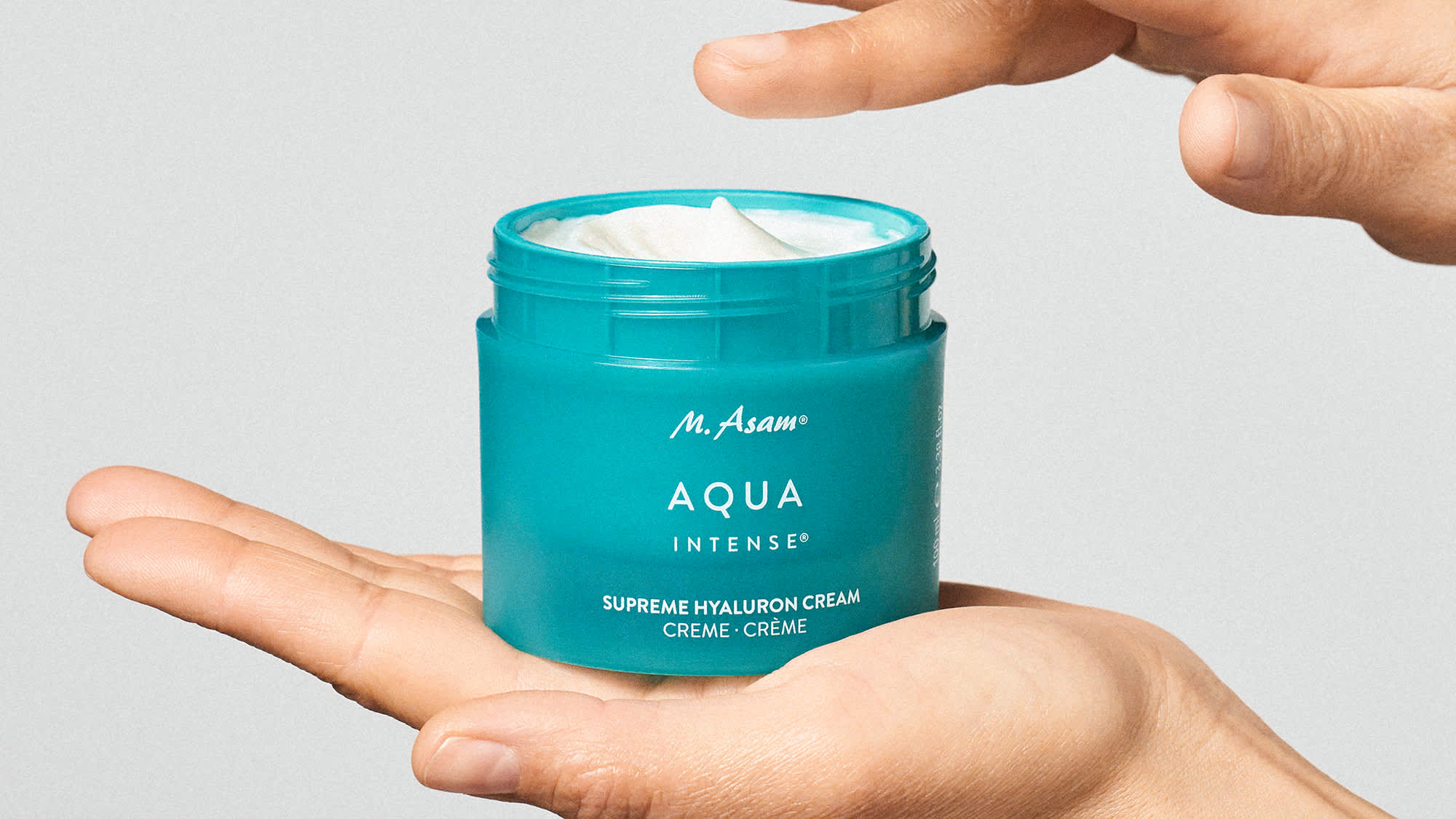 M. Asam AQUA INTENSE Creme im Tiegel, zwischen zwei Händen gehalten