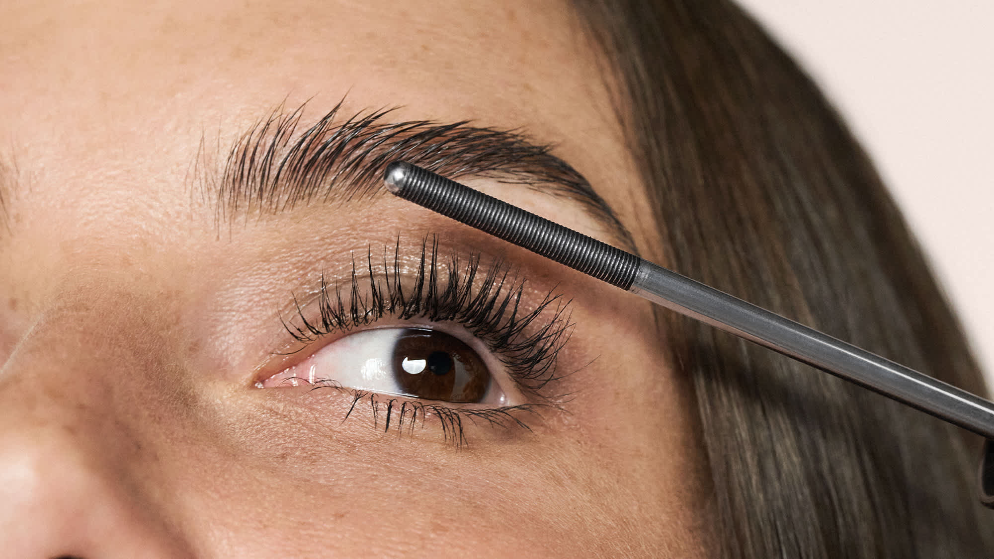 Anwendung einer Mascarabürste auf natürlich geschminkte Augen