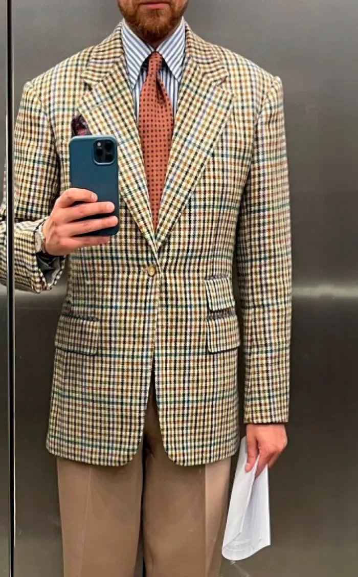 Client photographing his checked jacket in a mirror
