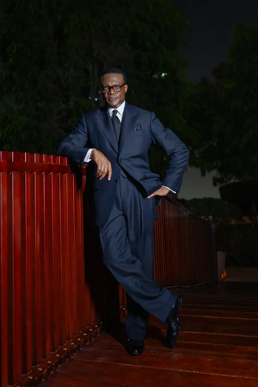 Navy single breasted suit against a red door