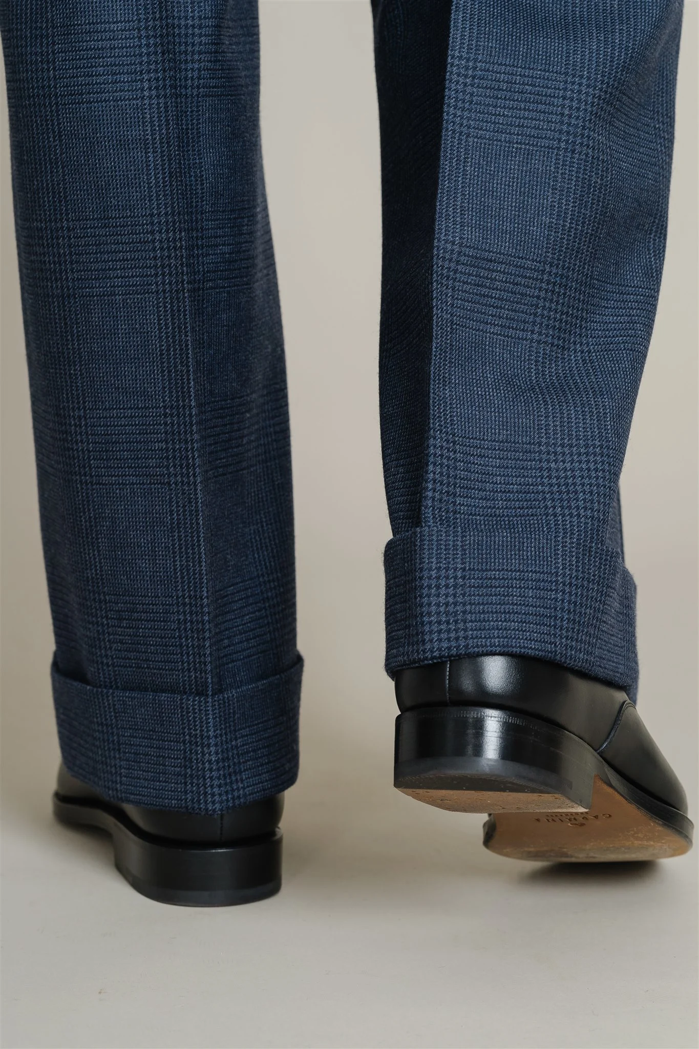 Close view of the trouser cuffs on the navy single breasted suit